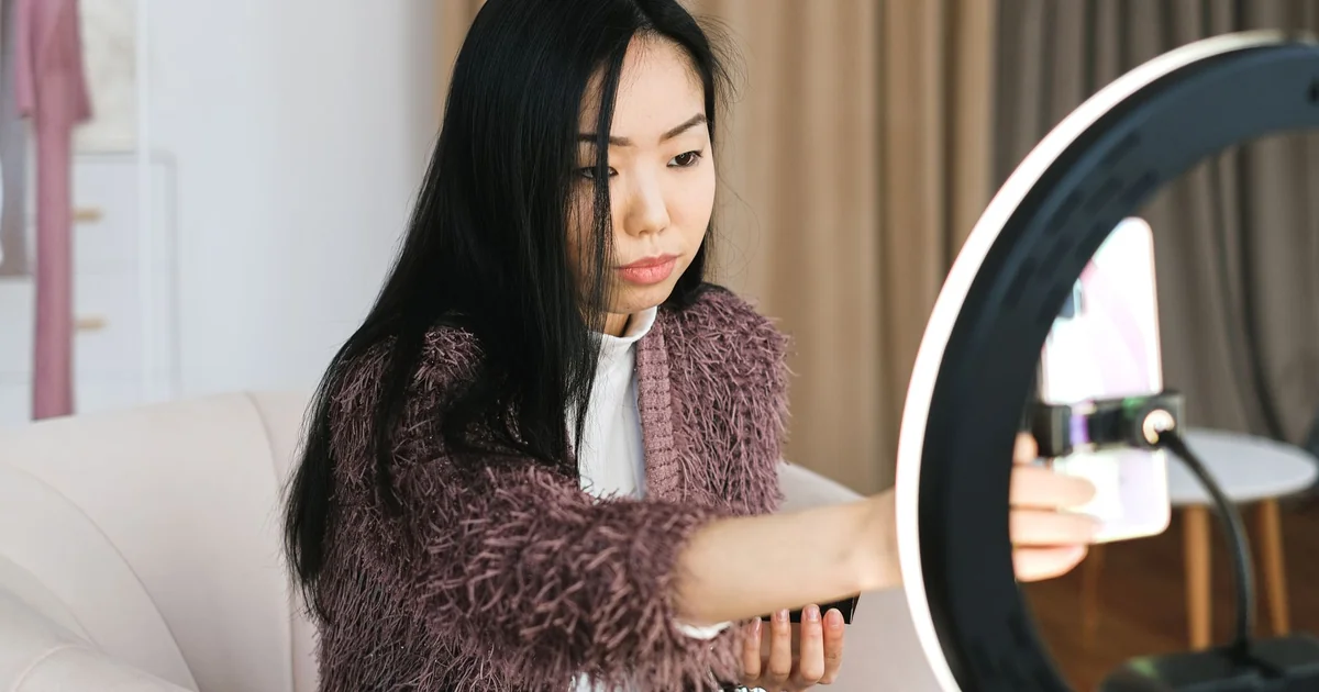 Créatrice de contenu filmant une vidéo verticale avec smartphone et ring light