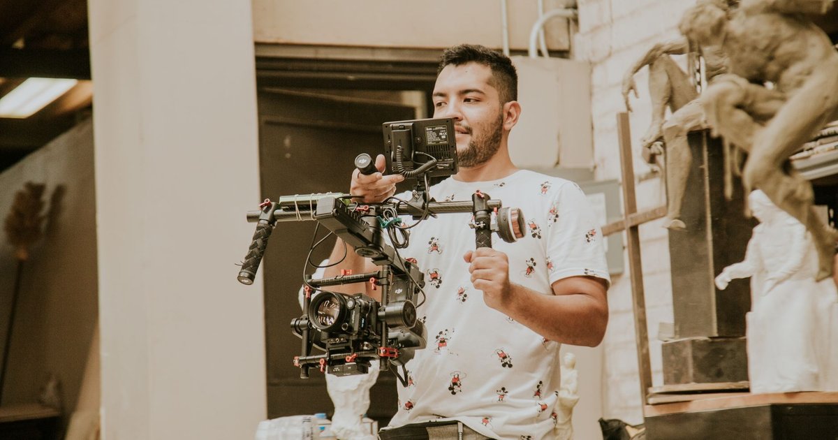 Opérateur vidéo filmant avec une caméra montée sur un stabilisateur dans un atelier
