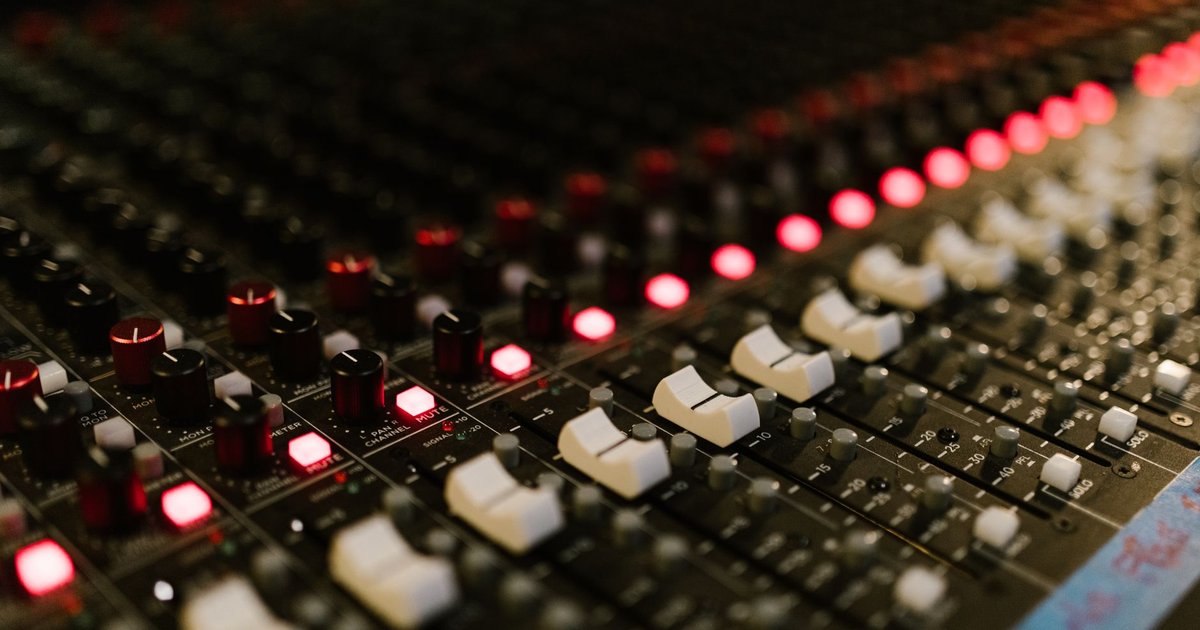 Console de mixage audio en gros plan, boutons rétroéclairés dans un studio d'enregistrement