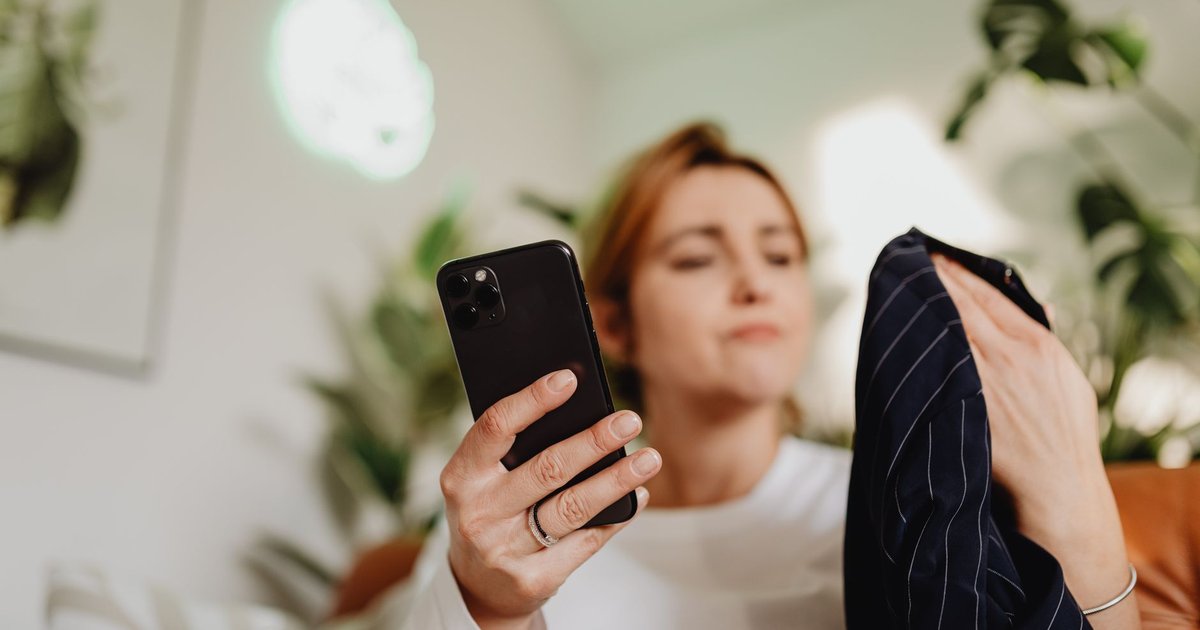 Femme faisant du shopping en ligne sur son smartphone, produits mode affichés à l'écran