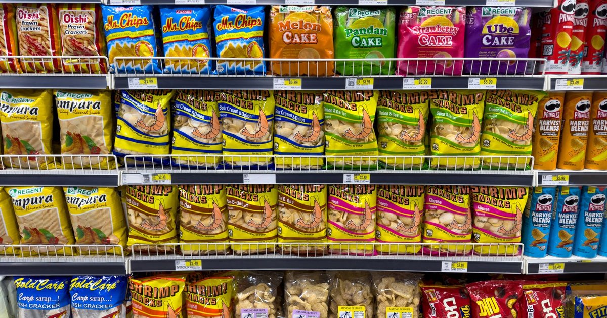 Rayon de supermarché rempli de paquets de snacks colorés alignés sur plusieurs étagères