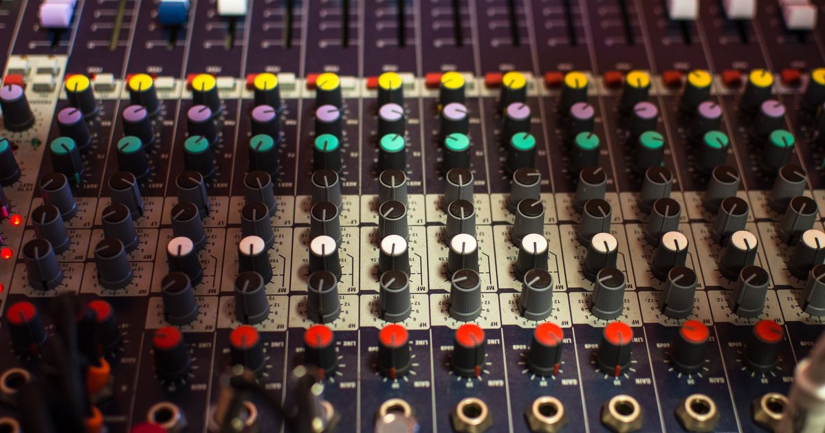 Console de mixage audio professionnelle aux réglages colorés dans un studio d'enregistrement éclairé
