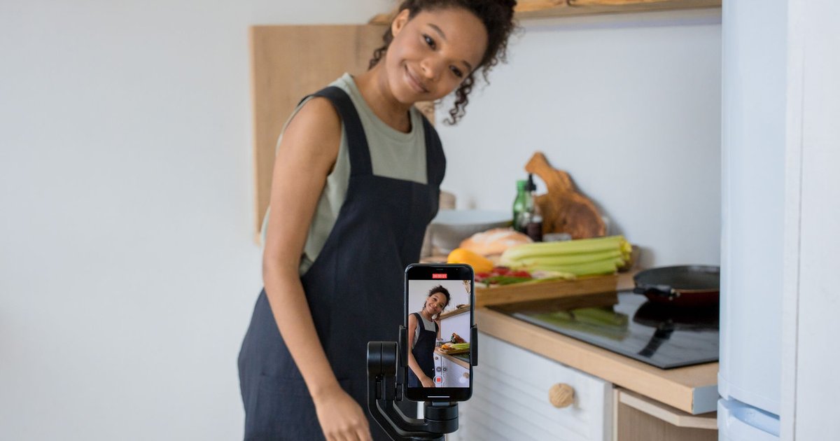 Créatrice filmant une vidéo culinaire au smartphone dans sa cuisine