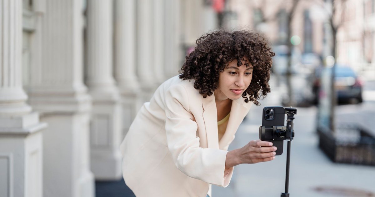 Créateur de contenu filmant une vidéo au smartphone monté sur trépied