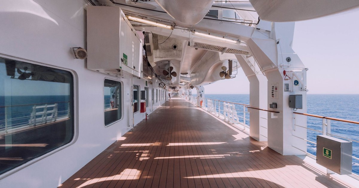 Pont promenade d'un navire de croisière sous les canots de sauvetage, face à la mer bleue